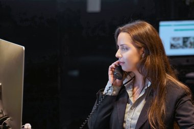 Bir ofis çalışanı close-up. Kadın Sekreter yanıtlayan telefon aramaları ve müşterilerle konuşurken, onun Resepsiyon çalışma oturuyor.