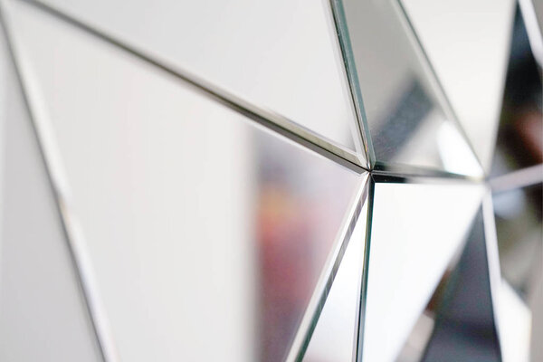 Mirror with crystals in wall, decoration and reflection. Abstract glass background. Polygonal surface. Close-up.