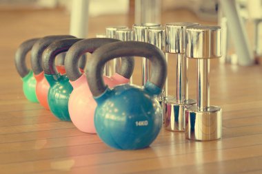 Renkli kettlebells üst üste bir spor salonunda. Tonlama
