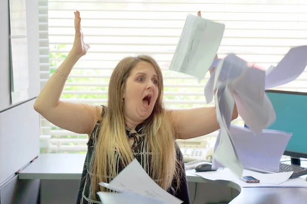 Overworked Angry businesswoman Throwing Paper All Over The Office. Stressed woman throwing charts or paperwork at office. Office worker female throws paper document pages in office.
