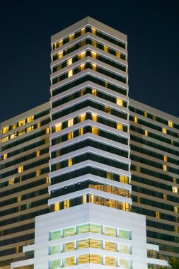 Şirket ofis binaları geceleri. Geç saatlere kadar. Yüksek doğmak modern bina geceleri ışık yansıtır. Yeni mahallede modern apartmanlar.