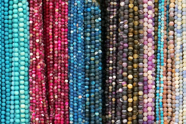 彩珠背景 彩色天然石珠的背景图案 各种颜色的珠子串 彩色珠子项链 女性工艺品时尚 — 图库照片