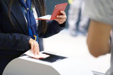 Havaalanında uçak yatılı için belgelerin incelenmesi hostes. Bir kadın Havaalanı çalışan yolcu pasaport denetler. Havaalanında bir turistik gezi bir adam. Seçici odak.