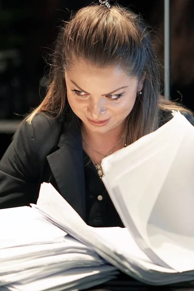 Close-up of office worker is distressed with a lot of paperwork in front of her. A lot of paper work in office. Yelling and screaming for bad results. Businesswoman in problems.