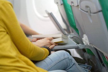 Genç bir adam karısıyla uçak ile ilgili bir kitap okur. Uçakla seyahat bir adam. Uçan bir kitabı okuma bir adam. Taşıma kavramı