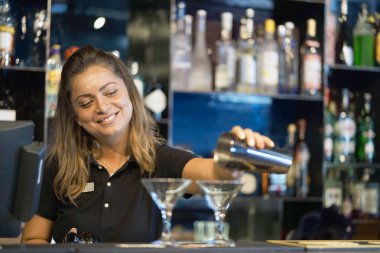 Profesyonel barmen kız taze kokteyl müşterilere otel barının dökülen. Barmen kız bir kokteyl içki alıyor. Hizmet kavramı. Barmen üzerinde odaklanmak.
