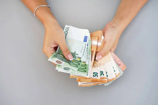 Woman hands that consider 100, 50-euro bills. In the hands of a lot of money, denominations of euros. Businesswoman hands hold and counting euro banknotes.