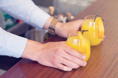 Barmen iki bardak portakal suyu otel restoran istemciye verir. Garson sipariş iki portakal suyu için otel barının istemciye aktarır. Hizmet kavramı. Tonlama