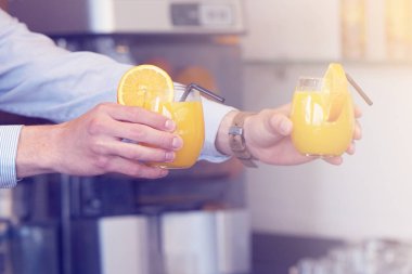 Barmen iki bardak portakal suyu otel restoran istemciye verir. Garson sipariş iki portakal suyu için otel barının istemciye aktarır. Hizmet kavramı. Tonlama