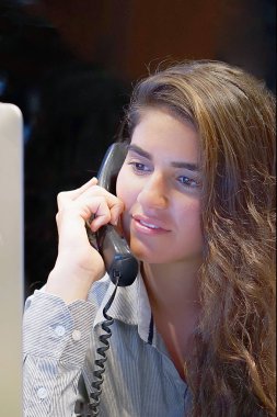 Bir ofis çalışanı Close-up. Kadın Sekreter yanıtlayan telefon aramaları ve müşterilerle konuşurken, onun Resepsiyon çalışma, oturuyor. Telefona bağıran kadın.