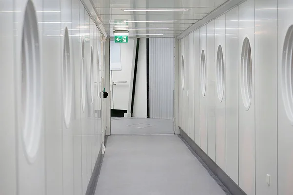 Passengers come on board the plane. Travelers, passenger walk to the plane plane through the docking station for pipes, inside the track. Empty room.