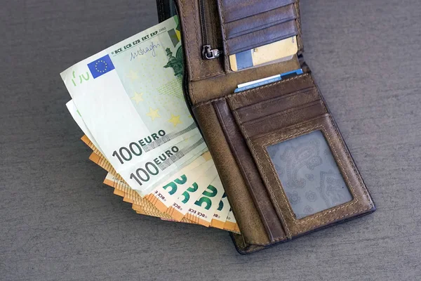 Wallet stuffed with Euro banknotes. Stuffed Leather Wallet. Euro Bills in Wallet. Leather wallet, fragment.