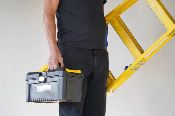 Electrician Holds Tool Box Yellow Wooden Ladder Builder Carries Wooden — Stock Photo, Image