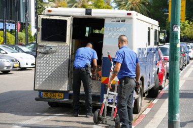 Brink kamyon'ın şirket koruma iki adam para çantaları arabaya koyun. Gardiyanlara para taşıma. Bankacılık zırhlı araba. Para taşıma silahlı muhafızlar. 11 Kasım 2018.Tel Aviv, İsrail.