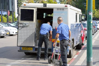 Brink kamyon'ın şirket koruma iki adam para çantaları arabaya koyun. Gardiyanlara para taşıma. Bankacılık zırhlı araba. Para taşıma silahlı muhafızlar. 11 Kasım 2018. Tel Aviv, İsrail.