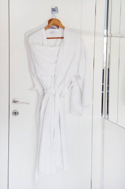 İki kat kapıda asılı beyaz. Otel sabahlıklar kapıda asılı üzerinde.