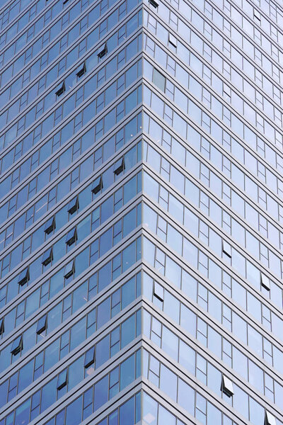 Angle modern business building skyscraper blue glass and aluminum, white square. Windows of facade. Modern apartment buildings in new neighborhood. Windows of a building, texture.