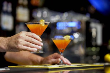 Barmen bir kokteyl otel barının istemciye verir. Taze kırmızı greyfurt ile kokteyl. Bardaki alkolsüz içki-içecek sayaç gece kulübü. Greyfurt kokteyl bardak.