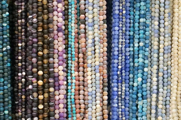 彩珠背景 彩色天然石珠的背景图案 各种颜色的珠子串 彩色珠子项链 女性工艺品时尚 — 图库照片