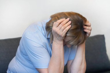 Yaşlı kadın evde baş ağrısı migren ağrısı muzdarip. Sağlık sorunu, stres ve depresyon. Erkek el ile kafa tutar. Sağlık kavramı.