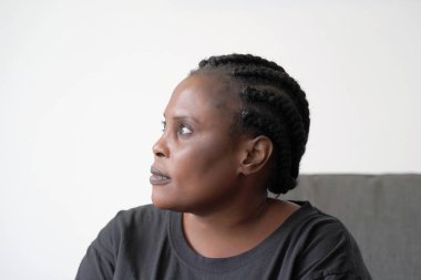 Yalnız Afrikalı kadın yatakta oturmuş üzücü. Bir güzel üzgün kız closeup portresi. Kadın hissediyorum depresyon.