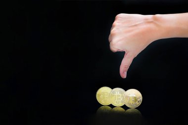Kadın kolunu başparmak aşağı işaret göster. Başparmak aşağı el imzala. Siyah arka plan üzerine izole yakın çekim altın sanal para bitcoin. Fiziksel Bitcoin. Kripto Döviz Ticaret kavramı.