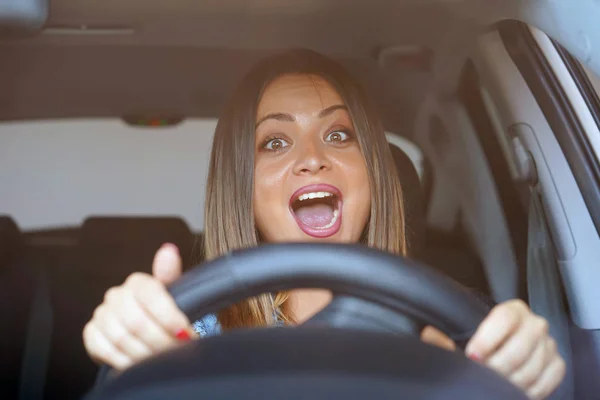 Fright face of woman, driving car. Closeup portrait displeased angry pissed off aggressive woman driving car. Emotional intelligence concept. Negative human expression