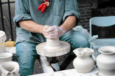 Teneke veya vazo gri kil oluşturma yakın çekim yakışıklı erkek. Adamın elleri yapmak bir kil sürahi, makro. Bir sürahi Potter yapar.