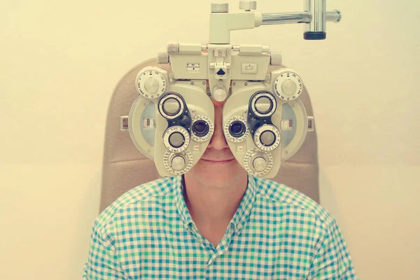 Male ophthalmologist examining patient man with optometrist trial frame. Man patient to check vision in ophthalmological clinic. Toning