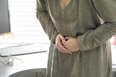 Yakın çekim ofis çalışanı kadın acı mide ağrısı sahip. Kronik gastrit. Beden ve sağlık kavramı.