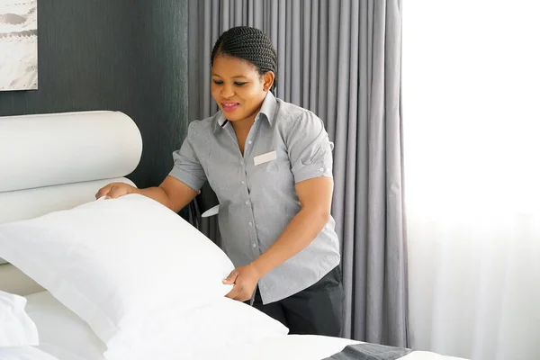 Otel odasında yatak yapma hizmetçi. Personel hizmetçi yapımı yatak. Afrika kahya yatak yapma.