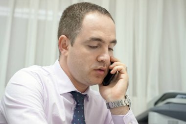 İş yerinde Evet iş adamı. Yakın çekim telefona cevap ve bir müşteri hizmetleri merkezi bir bilgisayar monitörü bakarak bir erkek ofis çalışanı. Otel resepsiyonist bilgisayar ve telefon kullanarak