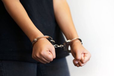 Tutuklanan kadın üzerinde gri backgroud izole elleri kelepçeli. Mahkum veya tutuklanan terörist, hacker, bribetaker, kelepçe elinde close-up.