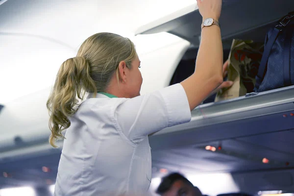 Die Stewardess Hilft Den Passagieren Ihr Gepäck Die Flugzeugkabine Legen — Stockfoto