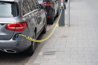 Elektrikli otomobil park yerinde elektrikli araç şarj istasyonu şarj. Bir elektrikli araba şarj ediliyor takılı güç kaynağının yakın çekim.