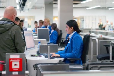 Havaalanı Bagaj terminal. Kadın Havaalanı çalışan havayolu memur Bagaj kaydeder. Bavul Bagaj konveyör kayış sistemi üzerinde. 8 Eylül 2018. Amsterdam Schiphol Havaalanı. Hollanda.