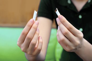 Eller genç kadın sigara yırtılma. Kırık bir sigara onun elinde tutan kız. Sağlıklı bir yaşam tarzı kavramı. Sigarayı.