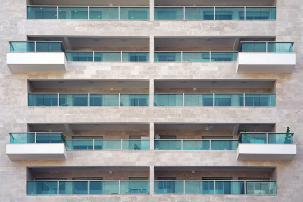 Glass grey square Windows of modern city business building skyscraper. Glass balconies in the building. Modern apartment buildings in new neighborhood. Windows of a building, texture.