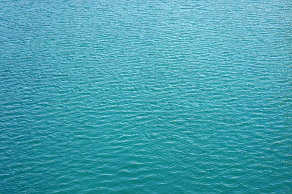 Blue rippled water as abstract background. Tranquil surface texture of the sea. Water ripples of a lake. Blue sea water in calm.