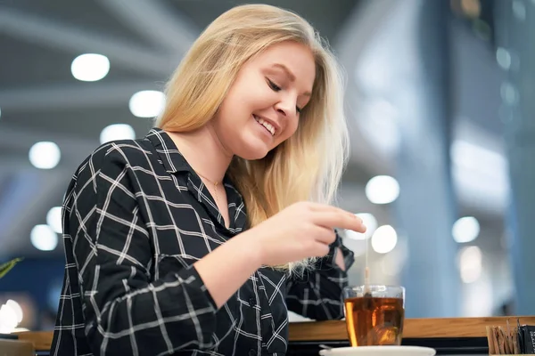 Joven chica rubia bebe té en un café —  Fotos de Stock