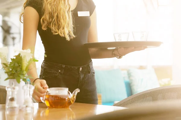 Chica trabajando como camarera sosteniendo una bandeja con té —  Fotos de Stock