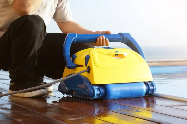 Hotel staff worker cleaning the pool. Automatic pool cleaners. — Stock Photo, Image