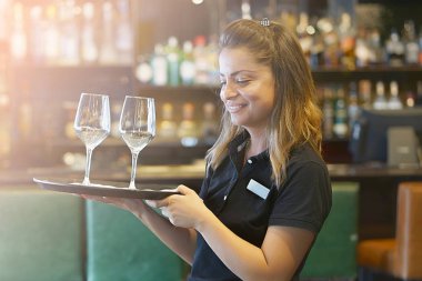 Garson bir şarap kadehi taşıyor