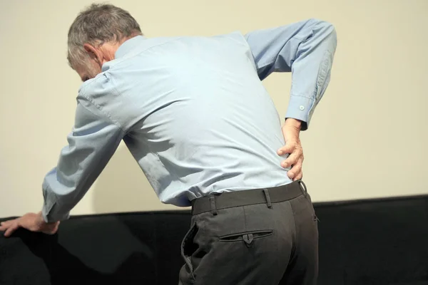 Elderly man, pain at lower back. Stock Image