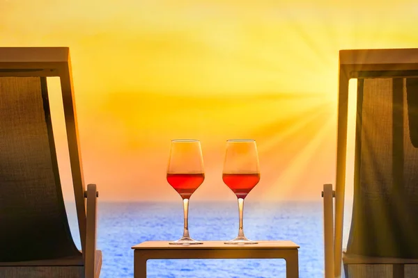 Bicchieri di vino rosso sullo sfondo rosso del mare . — Foto Stock