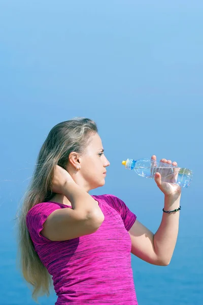 Menina com uma garrafa de água no fundo do mar — Fotografia de Stock