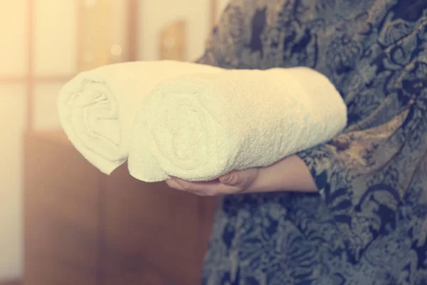 The woman is holding a rolled towel. — Stock Photo, Image