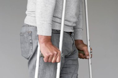Koltuk değneği olan adam. Yakın çekim. Yan görünüm
