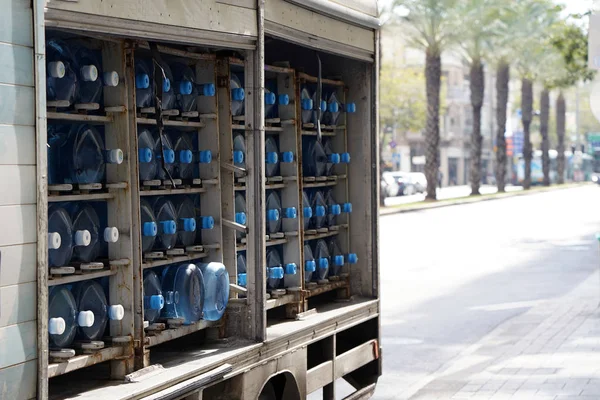 Muchos contenedores de agua en un coche. Cuerpo de coche con botellas de agua potable — Foto de Stock