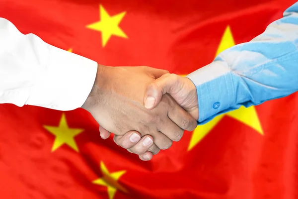 handshake on Chinese flag background.